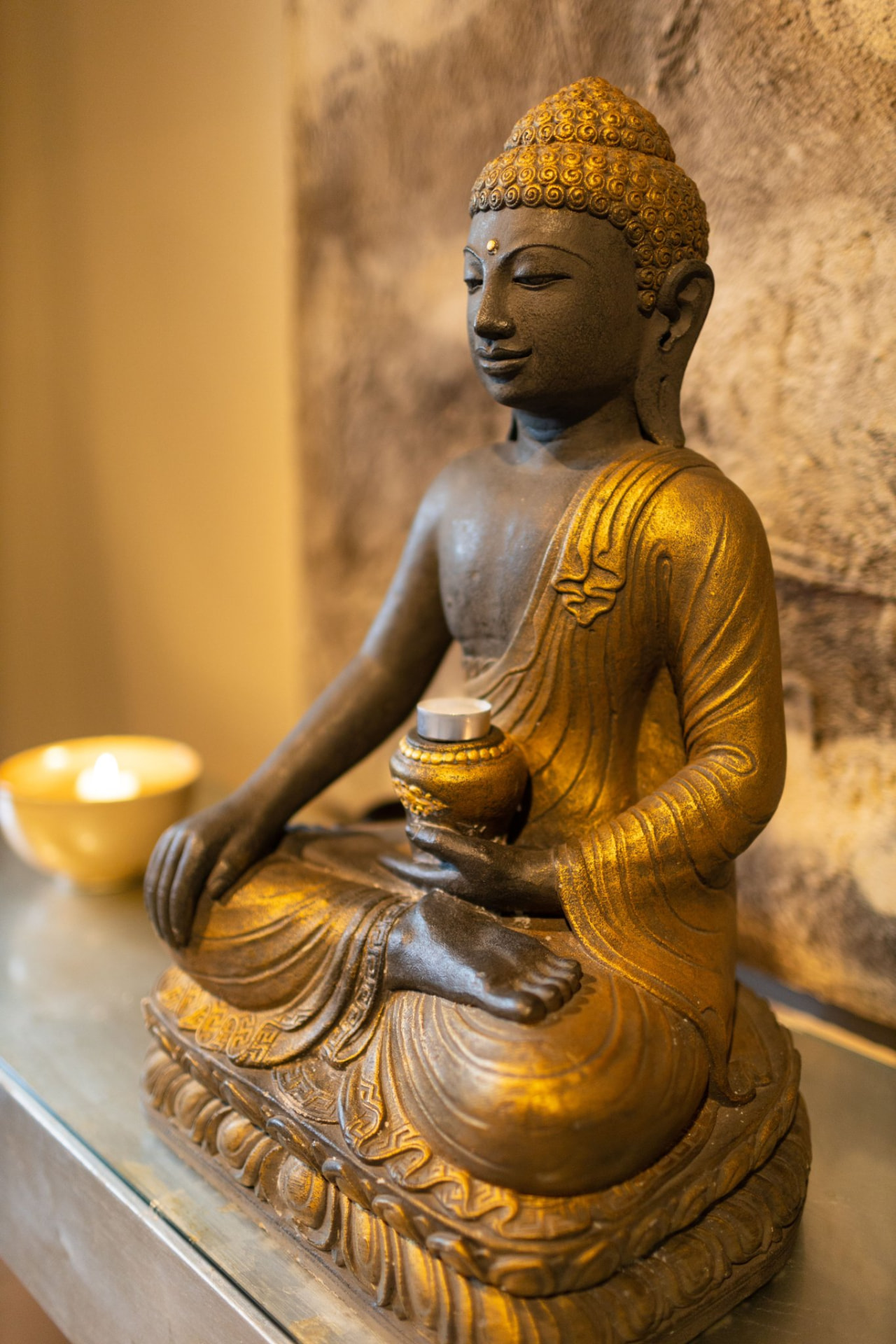 Goldene Buddha-Statue mit Kerzenlicht im Studio